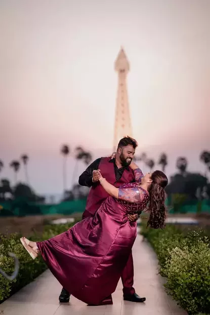 couple posing before the eiffel tower and sunset backdrop
